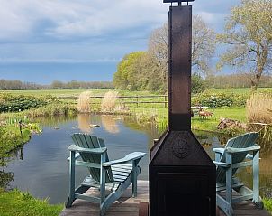 Schilderachtig uitzicht bij Huisje in Dieverbrug, Zuidwest Drenthe, met een houten sauna en bloeiende tuin.