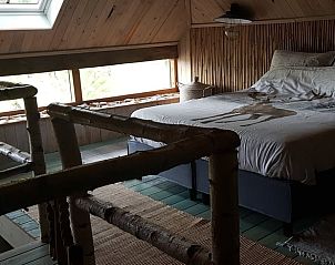 Slaapkamer in Huisje in Dieverbrug, Zuidwest Drenthe, met rustieke houten elementen en uitzicht op de natuur.