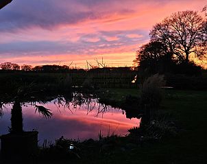 Luchtfoto van DG2027, een charmant vakantiehuis in Dieverbrug, Zuidwest Drenthe, omgeven door groene velden en rustieke natuur.