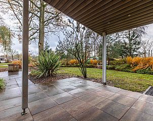 Veranda van Vrijstaande woning in Biddinghuizen met uitzicht op groene tuin in Oostelijk Flevoland, ideaal vakantiehuis voor natuurliefhebbers.