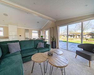 Gezellige woonkamer van Vakantiehuis Hackfort 6 in Biddinghuizen met uitzicht op de groene omgeving van Flevoland.