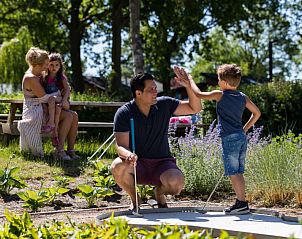 Vader en zoon spelen minigolf bij Vakantiehuis Hackfort 6 in Biddinghuizen, een leuke activiteit voor het gezin.