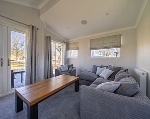 Lichte en ruime woonkamer in Vakantiehuis Hackfort 4, met uitzicht op het groene landschap van Biddinghuizen.