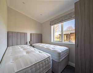 Slaapkamer met twee bedden in Vakantiehuis Hackfort 4 in Biddinghuizen, een rustige plek voor ontspanning in Oostelijk Flevoland.