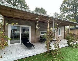 Veranda met ligstoelen bij Vakantiehuis Cosy Unique 4 in Biddinghuizen, perfect voor ontspanning in Oostelijk Flevoland.