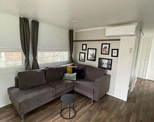 Gezellige woonkamer in Vakantiehuis Cosy Unique 4 in Biddinghuizen, biedt comfort en stijl in Oostelijk Flevoland.