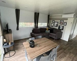 Ruime woonkamer met eetgedeelte in Vakantiehuis Cosy Unique 4 in Biddinghuizen, perfect voor familiebijeenkomsten.