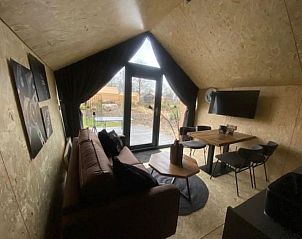 Binnenruimte van Vakantiehuis Solo Retreat 4 in Biddinghuizen, met comfortabele zithoek en eetgedeelte.