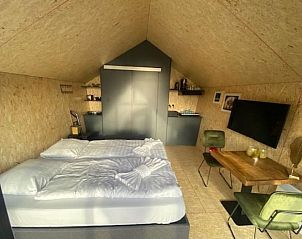 Comfortabele slaapkamer in Vakantiehuis Solo Retreat 2, Biddinghuizen, met uitzicht op de natuurlijke omgeving van Flevoland.