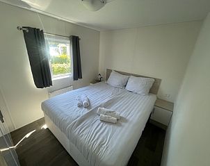 Ruime slaapkamer met tweepersoonsbed in Chalet in Biddinghuizen, biedt comfort in Oostelijk Flevoland.