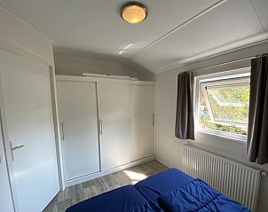 Ruime slaapkamer met opbergruimte in Chalet in Biddinghuizen, Oostelijk Flevoland, ideaal voor een ontspannen verblijf.