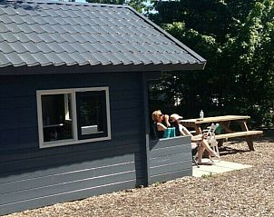 Duo genietend op het terras van Trekkershut 4 Personen in Biddinghuizen, Flevoland.