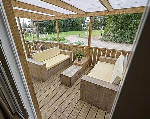 Outdoor seating with wooden furniture at Mobile home | 6 Persons, Biddinghuizen, Eastern Flevoland. Ideal for relaxation.