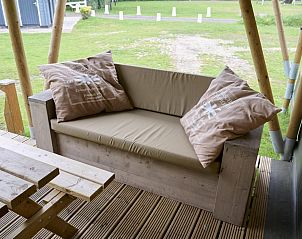 Houten bank met kussens op de veranda van Medley Lodge in Biddinghuizen, Oostelijk Flevoland, Flevoland.