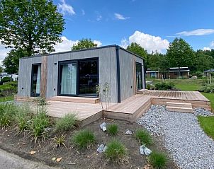 Chalet in Biddinghuizen, vakantiehuis in Oostelijk Flevoland met moderne buitenkant en houten terras.