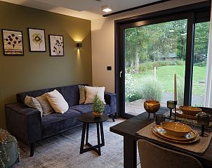 Gezellige zithoek in Chalet in Biddinghuizen, vakantiehuis in Oostelijk Flevoland met uitzicht op de tuin.