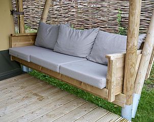 Comfortabele zithoek op de veranda van Safari Cottage in Biddinghuizen, perfect voor ontspanning in Flevoland.