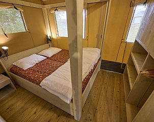 Slaapkamer met tweepersoonsbed in Safari Cottage, een vakantiehuis in Biddinghuizen, Flevoland.