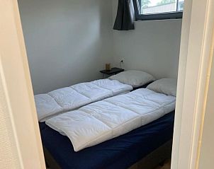Tweede slaapkamer in Vakantiehuis Cube Elite 6, Biddinghuizen, Flevoland met comfortabel bed en natuurlijk licht.