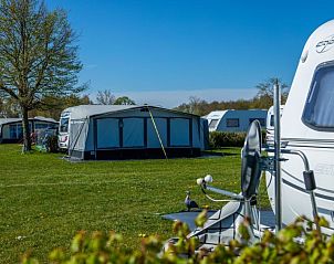 Caravanplaatsen in de buurt van Vakantiehuis Cube Elite 6, Biddinghuizen, Flevoland met groene velden en blauwe luchten.