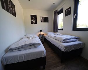 Slaapkamer met twee bedden in Vakantiehuis Cube Split 6, perfect voor een ontspannen verblijf in Biddinghuizen.