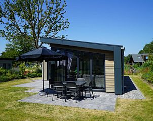 Zonnig terras van Vakantiehuis Cube Split 6 in Biddinghuizen, ideaal voor buitenmaaltijden in Flevoland.