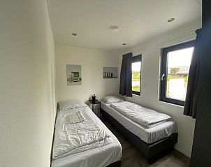 Gezellige slaapkamer met uitzicht op de natuur in Vakantiehuis Cube Split 6, perfect voor ontspanning in Biddinghuizen.