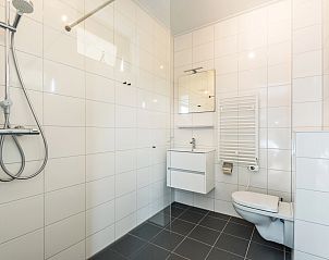 Comfortabele slaapkamer in Waterparc Veluwemeer bungalow Biddinghuizen, met uitzicht op de groene omgeving.