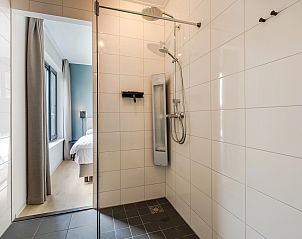 Slaapkamer in de 4-persoons bungalow Waterparc Veluwemeer, Biddinghuizen, met luxe bed en natuurlijke verlichting.