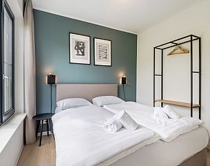 Slaapkamer in Waterparc Veluwemeer bungalow Biddinghuizen met uitzicht op speeltuin en comfortabele bedden.