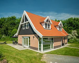 Buitenzijde Waterparc Veluwemeer 10-persoons villa in Biddinghuizen, Flevoland. Rood dak, groene omgeving en zonnig terras.