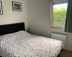 Slaapkamer in Chalet in Biddinghuizen, met uitzicht op de groene omgeving van Oostelijk Flevoland.