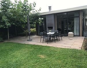 Terras van Chalet in Biddinghuizen met moderne buitenmeubelen en groene tuin in Flevoland.