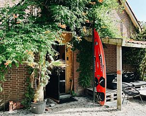 Entrance to Holiday Home in Rutten, Eastern Flevoland, with green plants and inviting atmosphere.