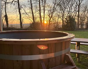 Hot tub overlooking sunset at Holiday Home in Rutten, Eastern Flevoland, for ultimate relaxation.