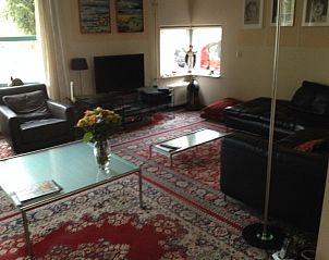 Gemtliches Wohnzimmer des Ferienhauses 350 Meter vom Strand in Zeewolde, Flevoland, mit bequemen Sitzgelegenheiten und warmer Einrichtung.