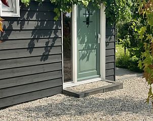 Front door of Holiday home in Kraggenburg with gravel path in Eastern Flevoland.
