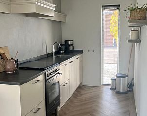 Spacious kitchen in Holiday home in Kraggenburg with contemporary appliances in Flevoland.