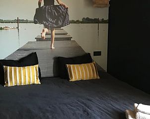 Atmospheric bedroom in Holiday Home in Kraggenburg with artistic wall decoration in Eastern Flevoland.