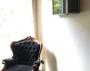 Comfortable sitting area in cottage in Kraggenburg with classic armchair in Flevoland.