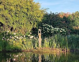 Sculpture in the garden of Holiday home in Kraggenburg, surrounded by flowers in Eastern Flevoland, Flevoland.