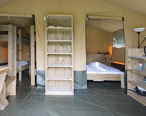 Gezellige binnenruimte van Glampingtent de Meeuw in Zeewolde, Zuidelijk Flevoland, met comfortabele bedden en houten interieur.
