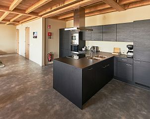 Moderne keuken in Groepsaccommodatie 't Wolderwijd, een vakantiehuis in Zeewolde, Zuidelijk Flevoland, met strakke inrichting en houten balken.