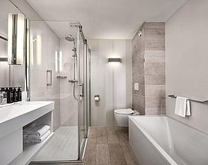 Luxe badkamer in WestCord Hotel Schylge, West-Terschelling met douche en ligbad.