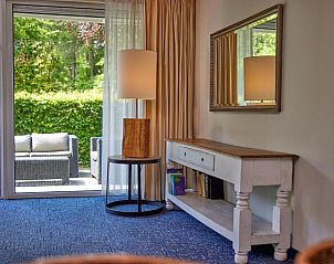 Gezellige woonkamer met uitzicht op het terras bij WestCord ApartHotel Boschrijck, West-Terschelling.