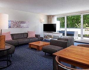 Gezellige zithoek in WestCord ApartHotel Boschrijck, West-Terschelling met uitzicht op de tuin.