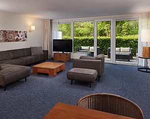 Ruime woonkamer met comfortabele banken in WestCord ApartHotel Boschrijck, West-Terschelling.