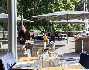 Buitenterras met uitzicht op de tuin bij WestCord ApartHotel Boschrijck, West-Terschelling.