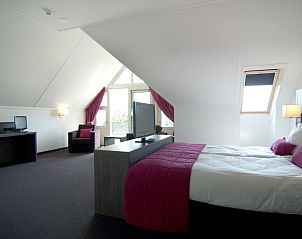 Luxe slaapkamer in Hotel Bornholm, West-Terschelling, met comfortabel bed en werkruimte.