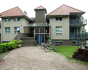 Buitenkant van Hotel Bornholm, West-Terschelling, met fietsenstalling en groene omgeving.